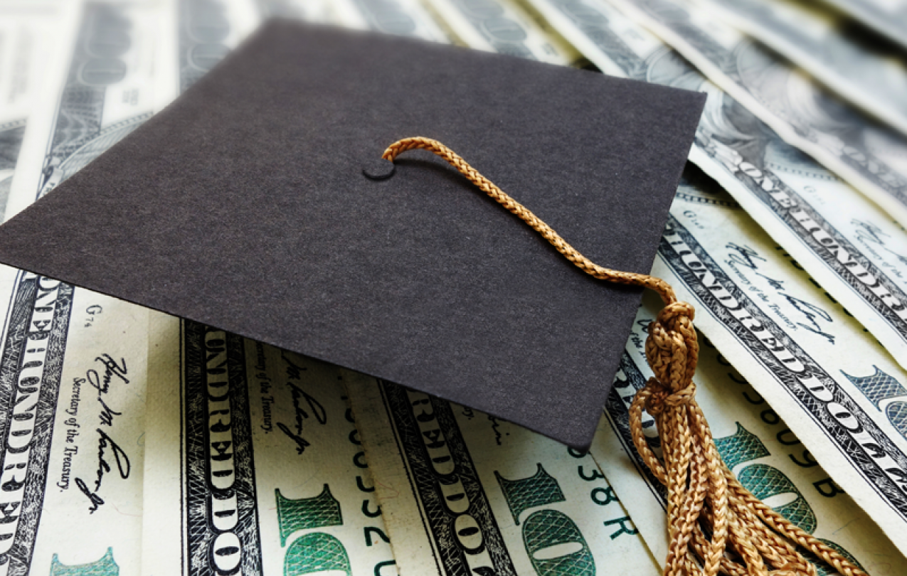 Graduation cap on top of money. Photo credit: Getty Images